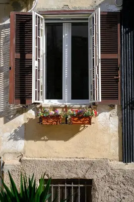 a window with flowers on the ledge of a building at Testaccio Guest House in Rome