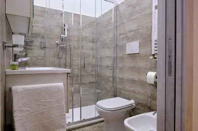 a bathroom with a shower and a toilet and a sink at Testaccio Guest House in Rome