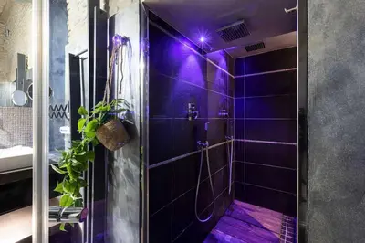 a purple bathroom with a shower with purple tiles at Manara 57 Dream Apartment Trastevere in Rome