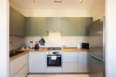 a kitchen with white appliances and green cabinets at AURELIA SUNSET PENTHOUSE by Rental in Rome in Rome
