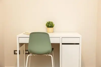 a white desk with a green chair and a plant at AURELIA SUNSET PENTHOUSE by Rental in Rome in Rome