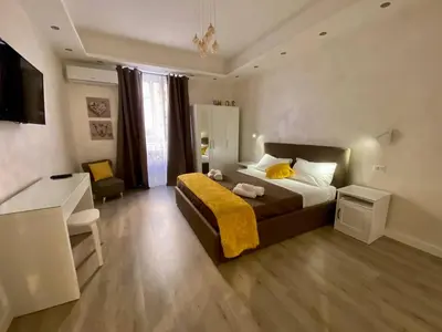 a bedroom with a bed with a yellow blanket on it at Apartment near the Colosseum, with metro line A a 2 minutes walk away in Rome