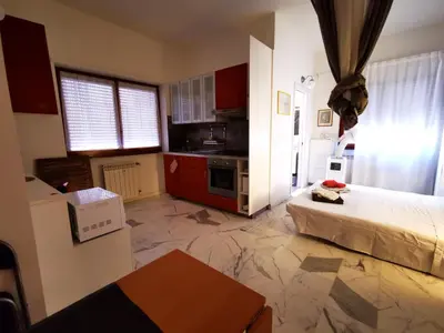a small room with a bed and a kitchen at Rouge Studio - 10 min from Vatican in Rome