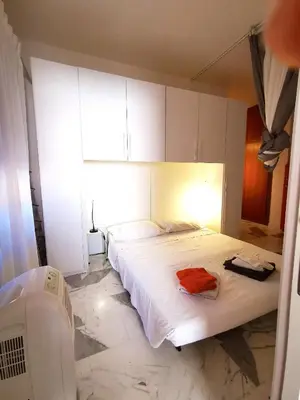 a bedroom with a large white bed and a window at Rouge Studio - 10 min from Vatican in Rome