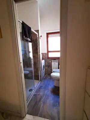 a bedroom with a large white bed and a television at Rouge Studio - 10 min from Vatican in Rome