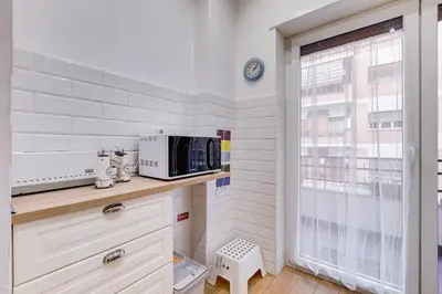 a kitchen with a counter with a microwave and a window at JMartins Vatican suites in Rome