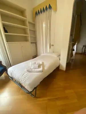 a bedroom with two beds with white sheets and shelves at Vicario138 in Rome