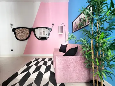 a room with a pink couch and a plant at Domus Colosseum by JFM - Cozy apartment nearby Colosseum in Rome