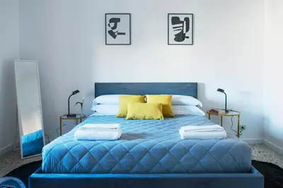 a bedroom with a blue bed with yellow pillows at Myway RDR Apartment in Rome