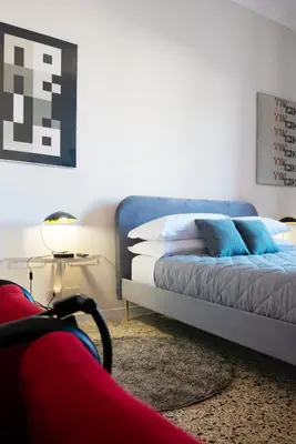 a bedroom with a bed with blue pillows and a table at Myway RDR Apartment in Rome