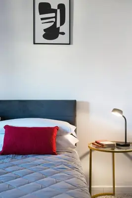a bedroom with a bed with a red pillow and a table at Myway RDR Apartment in Rome
