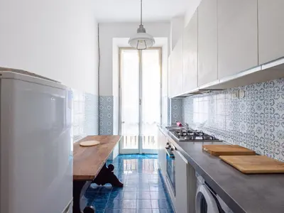 a kitchen with white cabinets and a blue tile floor at Apartment Virgilio by Interhome in Rome