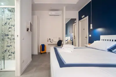 a bedroom with a white bed and a blue wall at Veniero37 Guest House in Rome