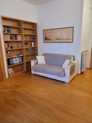a living room with a couch and a book shelf at Lovely Suite accogliente appartamento tra Policlinico e Piazza Bologna in Rome