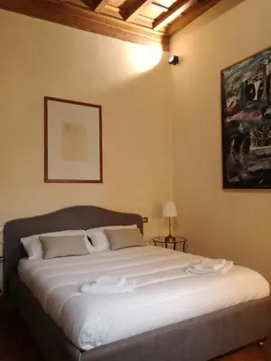 a bedroom with a large bed with white sheets at Apartment in a 1400s building in Via dei Coronari Piazza Navona in Rome