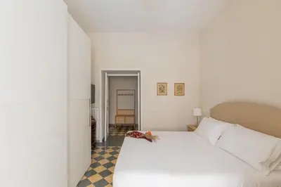a bedroom with a white bed and a checkered floor at iFlat Vatican Elegant Apartment in Rome