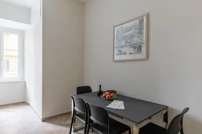 a dining room with a black table and chairs at iFlat Vatican Elegant Apartment in Rome