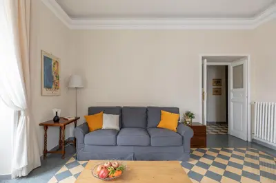 a living room with a blue couch and a table at iFlat Vatican Elegant Apartment in Rome