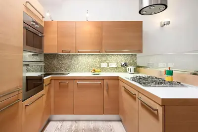 a kitchen with wooden cabinets and a stove top oven at Modern Colosseum Flat in Rome