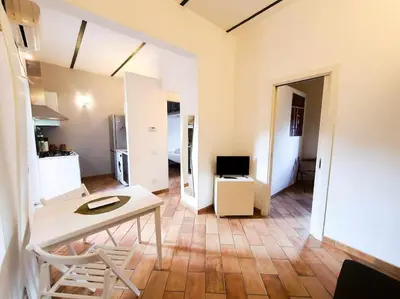a living room with a table and a kitchen at Cozy Apartment in Pigneto up to 4 in Rome