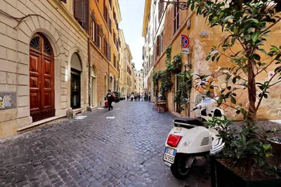 a white scooter parked on a cobblestone street at Bright Penthouse Downtown in Rome