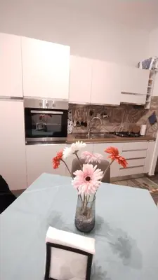 a vase of flowers sitting on a table in a kitchen at Appartamento Fiore Roma San Pietro in Rome