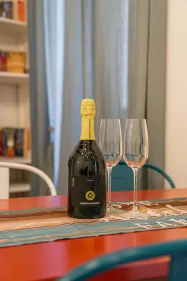 a bottle of wine sitting on a table with two wine glasses at Campo de' Fiori appartamento via di Grotta Pinta in Rome