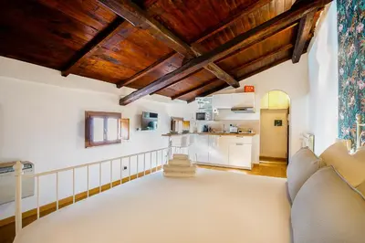 a living room with white walls and wooden ceilings at Magikrooms Muse in Rome
