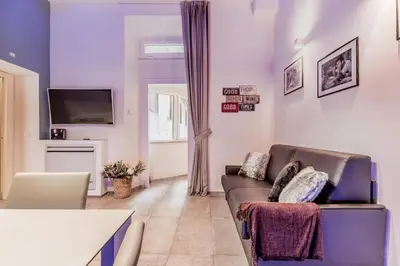 a living room with a couch and a tv at TH Trastevere Luxury-S.Cosimato 2bd-2bt in Rome