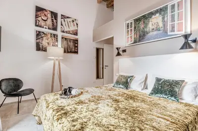 a bedroom with a bed and a chair at TH Trastevere Luxury-S.Cosimato 2bd-2bt in Rome