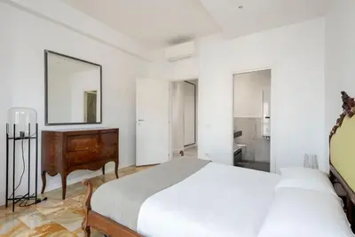 a white bedroom with a bed and a dresser at Vatican Dome View Apartment in Rome