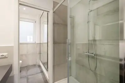 a shower with a glass door in a bathroom at Vatican Dome View Apartment in Rome