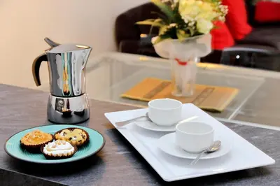 a table with two cups and a plate with cupcakes at 4BNB - Cozy Albornoz Flat in Rome