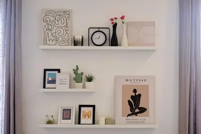a white wall with two shelves with pictures on it at Remuria Domus in Rome