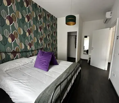 a bedroom with a bed with a purple pillow on it at DOMUS H501 in Rome