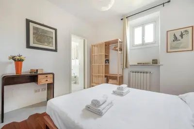 a white bedroom with a white bed and a window at Residenza Urbana in Rome