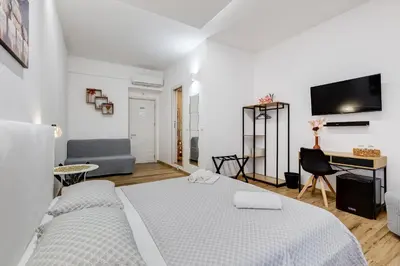 a white bedroom with two beds and a desk at VATICANDREAM GUEST HOUSE in Rome