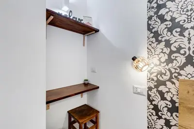 a room with a shelf on the wall and a table at VATICANDREAM GUEST HOUSE in Rome
