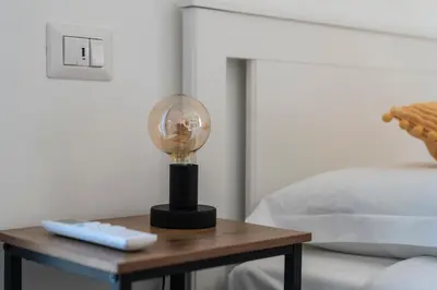 a table with a lamp on it next to a bed at Vintage Cipro Apartment in Rome