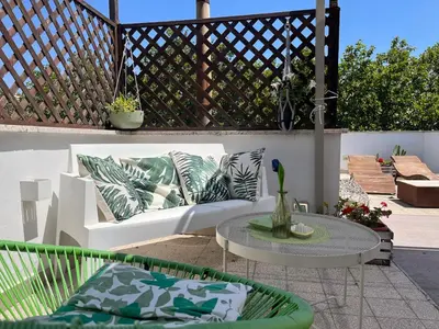 a patio with a white couch and a table at Monteverde Double Terrace Penthouse in Rome