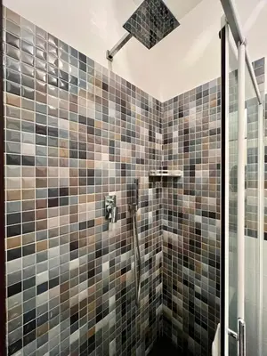 a bathroom with a shower with brown tiles at C&Y Apartments - Roma Vaticano St Peter - Luxe Penthouse Flat in Rome