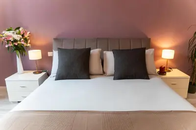 a bedroom with a large white bed with two lamps at C&Y Apartments - Roma Vaticano St Peter - Luxe Penthouse Flat in Rome