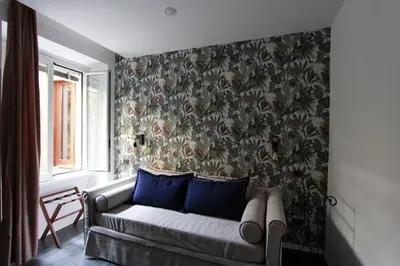 a living room with a couch against a wall with a wallpaper at Avignonesi Flat in Rome