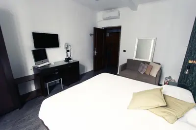 a bedroom with a bed and a chair and a television at Avignonesi Flat in Rome
