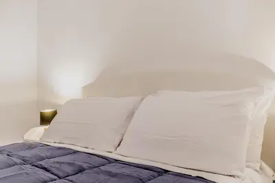 a bed with white sheets and pillows on it at MARCONI31Eredia in Rome