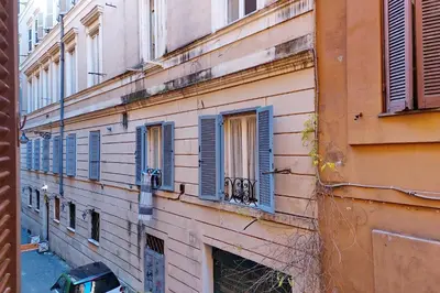 a building with blue shutters on the side of it at YCH-Bright Suite Navona in Rome