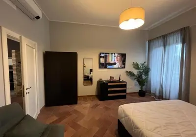 a bedroom with a bed and a flat screen tv at StarHome San Paolo in Rome
