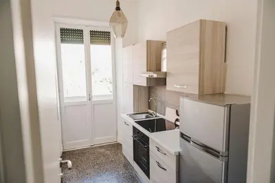 a small kitchen with a refrigerator and a sink at La Casa di Klaudia in Rome