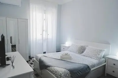a white bedroom with a white bed and a window at La Casa di Klaudia in Rome