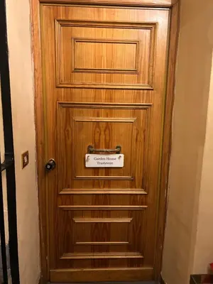 a wooden door with a sign on it at Garden House Trastevere in Rome